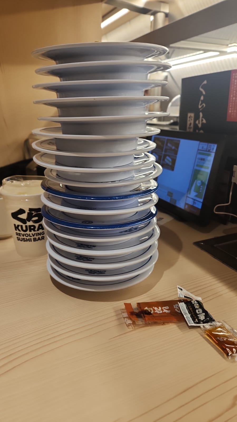 A tall stack of empty plates at Kura Sushi