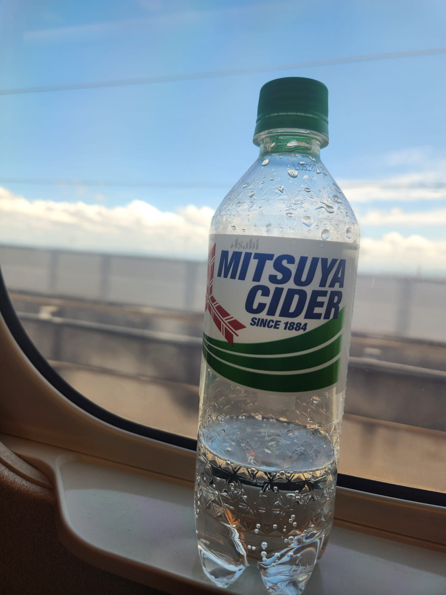 A bottle of Mitsuya Cider on a shinkansen tray table