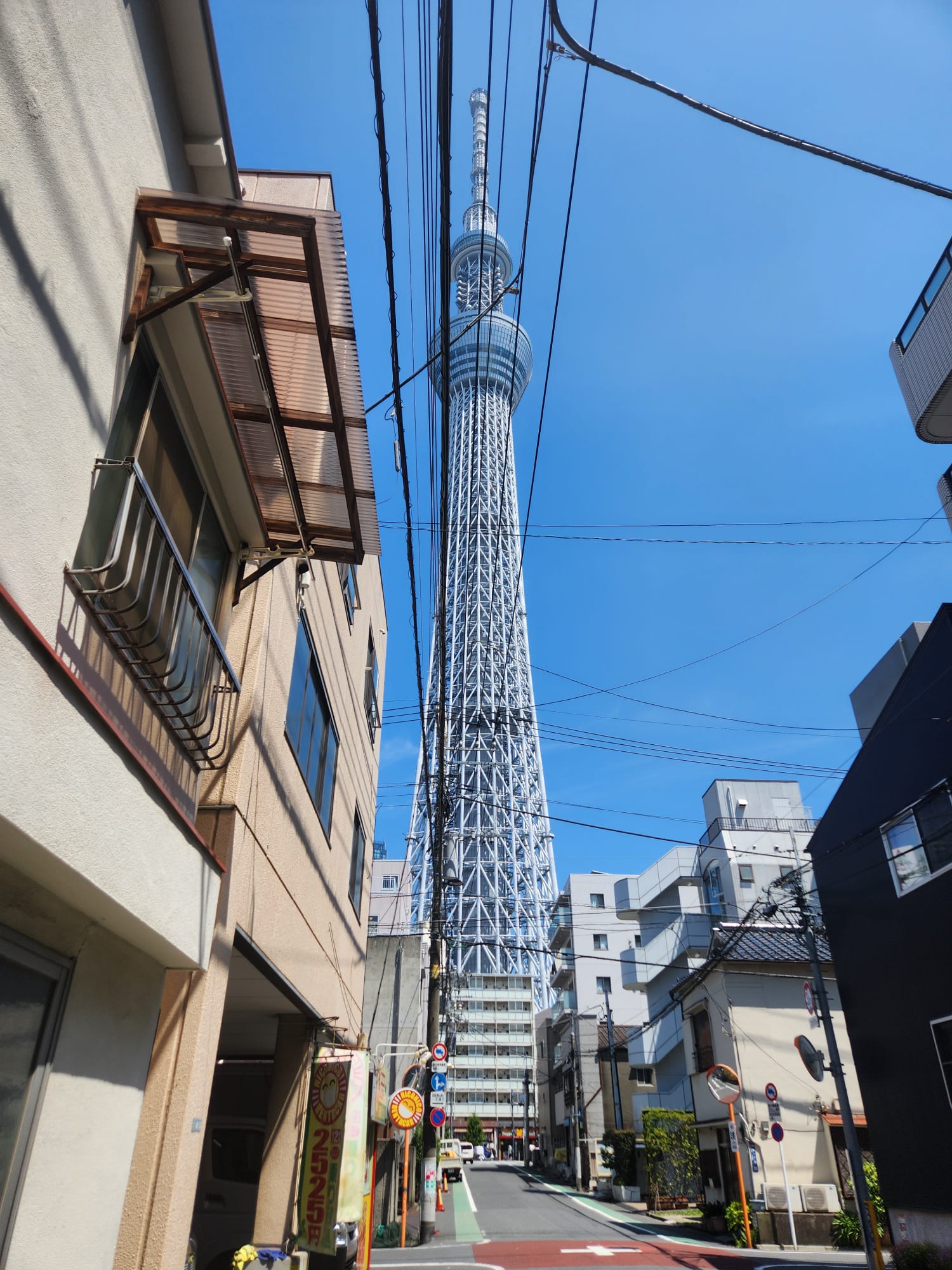 Tokyo Skytree rising above a narrow backstreet